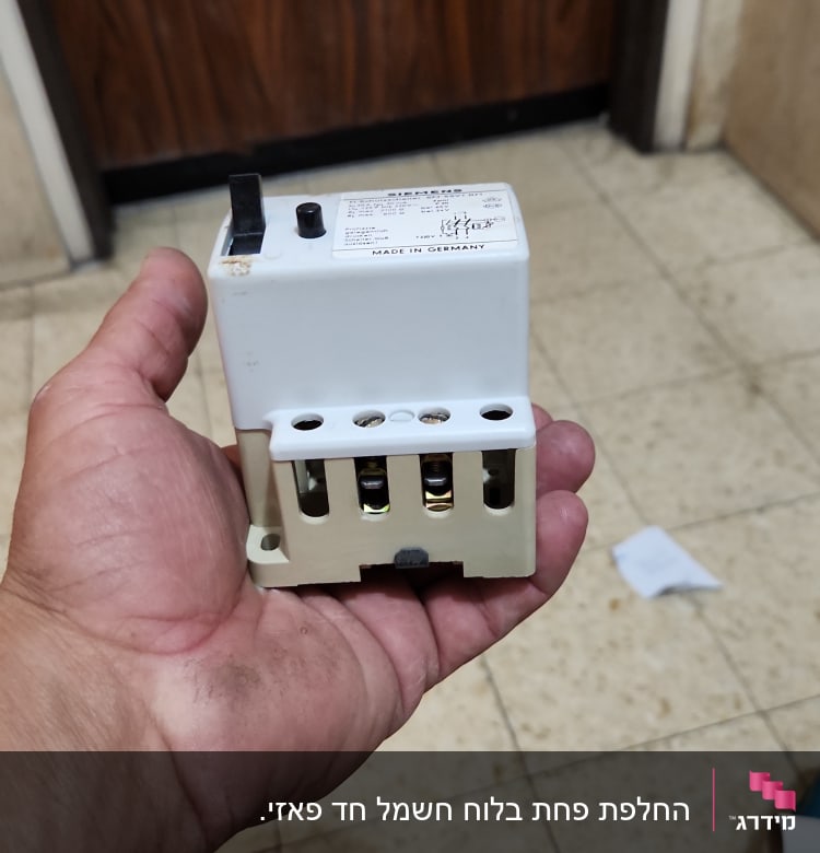 יד מחזיקה רכיב חשמלי עם חיבורים
